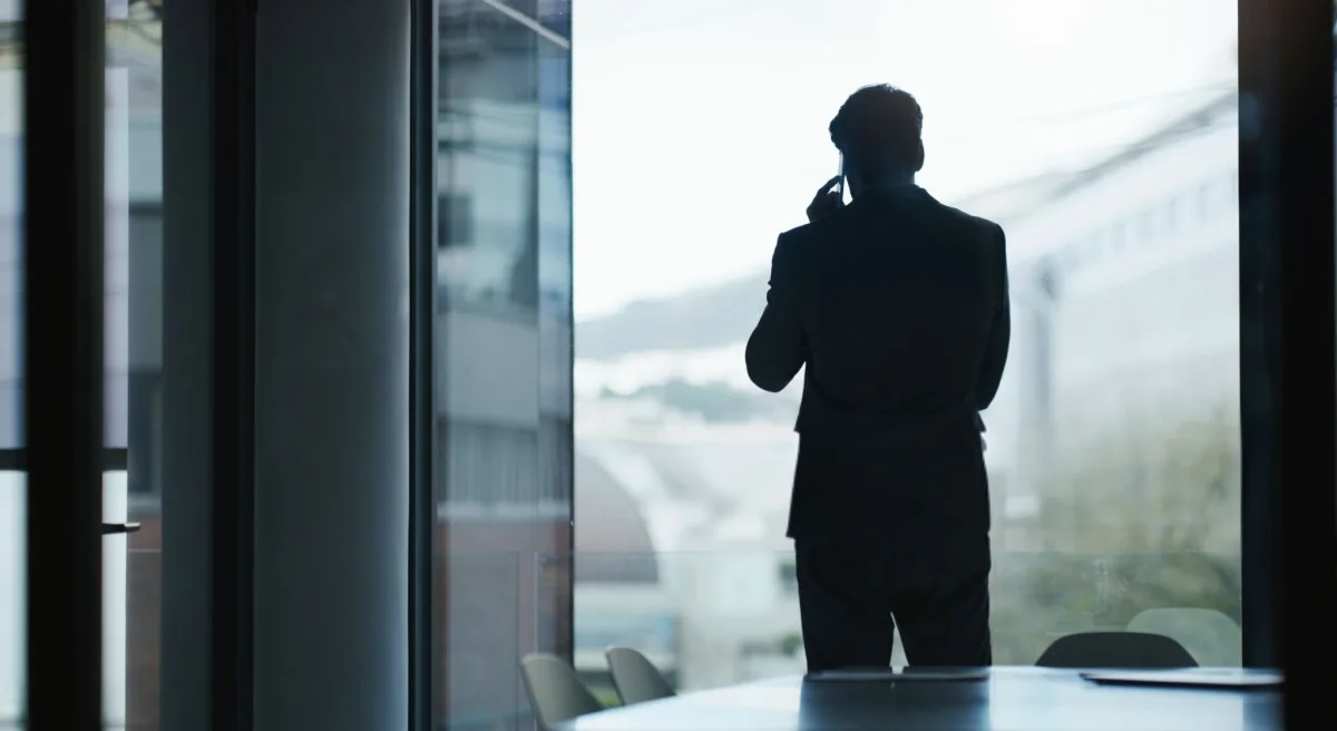 An investigator on the phone at an office window